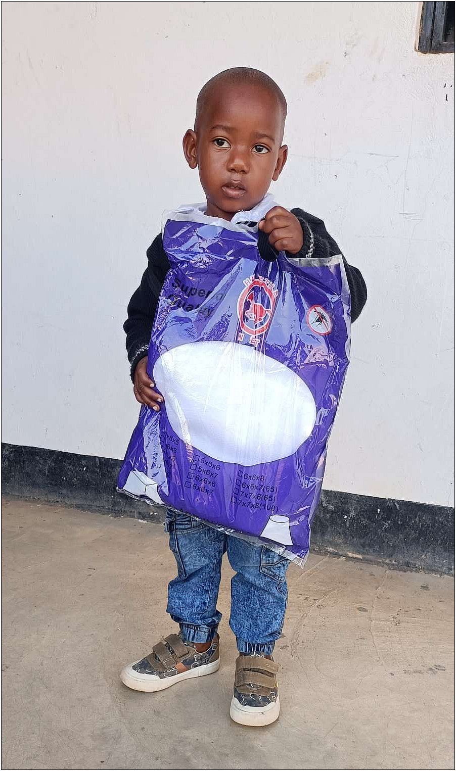 Laurent holding his mosquito net